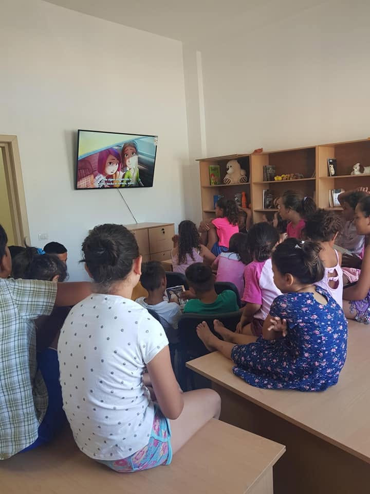 Children watching a film together in an activity room